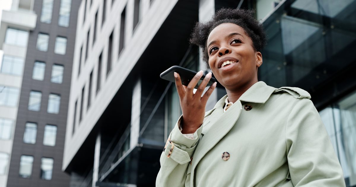 Femme qui passe un appel téléphonique en extérieur avec son smartphone, avant de composer un numéro surtaxé en 0820