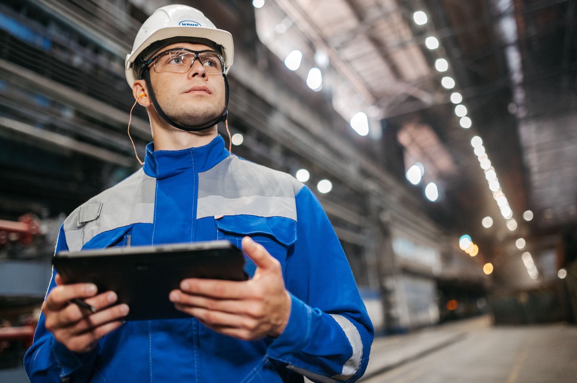 Technicien inspectant un équipement industriel sur tablette
